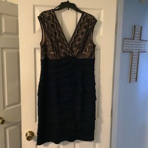 Elegant dark blue dress with layered ruffle skirt and lace overlay on bodice